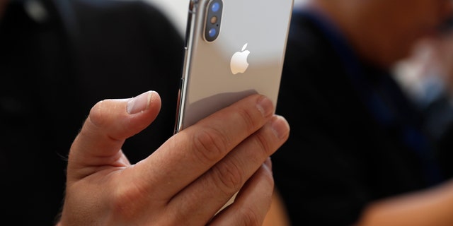 File photo: An attendee checks out an iPhone X. (Reuters/Stephen Lam) 