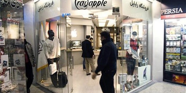 A man walks in front of a shop selling Apple products at a mobile and computer shopping complex in northern Tehran in 2011. (Reuters)