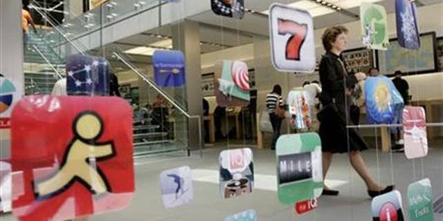 A woman walks past icons for Apple applications at the company's retail store in San Francisco, California.