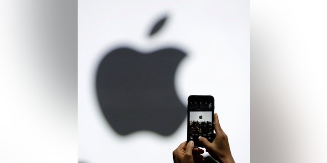 FILE - In this Monday, June 5, 2017, file photo, a person takes a photo of an Apple logo before an announcement of new products at the Apple Worldwide Developers Conference in San Jose, Calif. Apple is expected to demand $1,000 for the fanciest iPhone that it has ever made, thrusting the market into a new financial frontier that will test how much consumers are willing to pay for a device that has become an indispensable part of modern life. (AP Photo/Marcio Jose Sanchez, File)