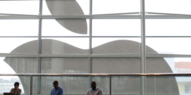 File photo - Attendees sit in front of an Apple logo at the Apple Worldwide Developers Conference (WWDC) 2013 in San Francisco, Calif. June 10, 2013. (REUTERS/Stephen Lam)