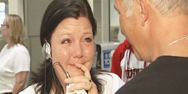 April Beaver listens to her deceased son Caleb's heart, beating in donor recipient Chuck Shelton's chest, through a stethoscope.