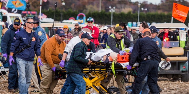 Paramedics transport a man to an ambulance after he was injured when an apparatus used to launch pumpkins into the air exploded at the World Championship Punkin Chunkin Contest in Bridgeville, Del., Sunday, Nov. 6, 2016.