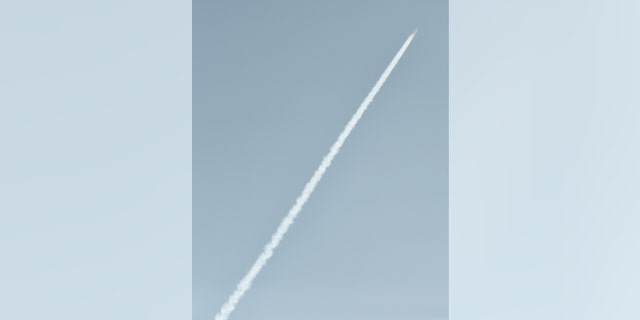 An unidentified object, believed to be a North Korean rocket, streaks across the sky.