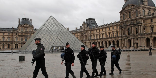 Armed police officers patrol in the courtyard of the Louvre museum near where a soldier opened fire after he was attacked in Paris, Friday, Feb. 3, 2017.