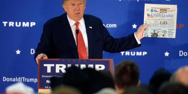 Dec. 28, 2015: Republican presidential candidate Donald Trump displays a copy of the Union Leader newspaper while addressing an audience during a campaign event.