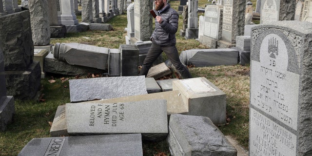 Rabbi Joshua Bolton of the University of Pennsylvania's Hillel center surveys damaged headstones at Mount Carmel Cemetery on Monday, Feb. 27, 2017, in Philadelphia. More than 100 headstones have been vandalized at the Jewish cemetery in Philadelphia, damage discovered less than a week after similar vandalism in Missouri, authorities said. (AP Photo/Jacqueline Larma)