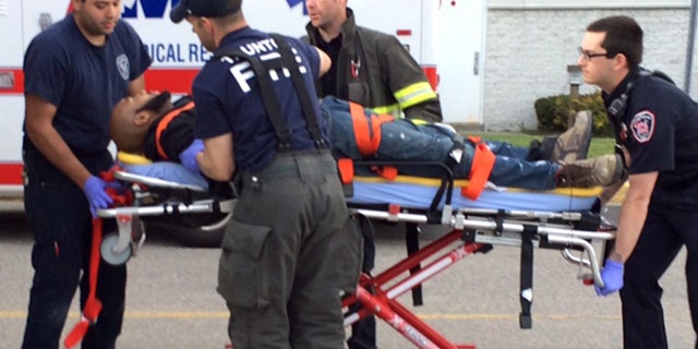 May 10, 2016: The suspect in the attacks at the Silver City Galleria mall in Taunton, Mass. is transported on a gurney into an ambulance by medical personnel.