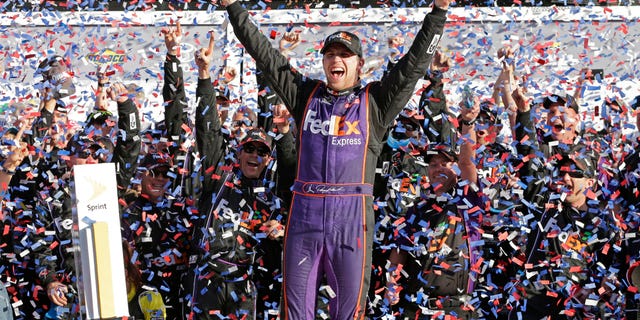 Denny Hamlin celebrates in Victory Lane after winning the NASCAR Daytona 500 Sprint Cup Series auto race.