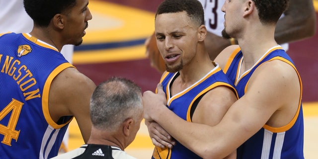 June 16, 2016: Golden State Warriors guard Stephen Curry is held back from referee Jason Phillips by Shaun Livingston, left, and Klay Thompson, right, while reacting to being called for his sixth foul during Game 6 of the NBA Finals