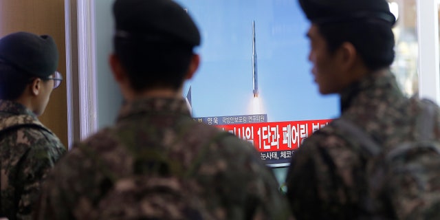 South Korean soldiers watch a news program about North Korea's rocket launch.