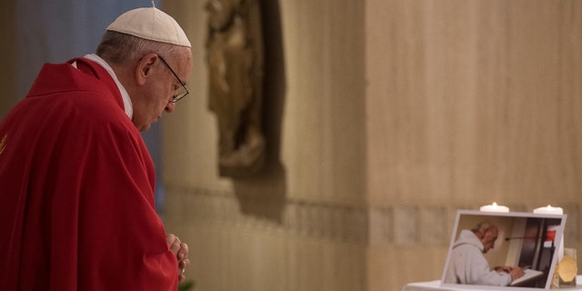 Pope Francis prays in front of a picture of Rev. Jacques Hamel on Wednesday.
