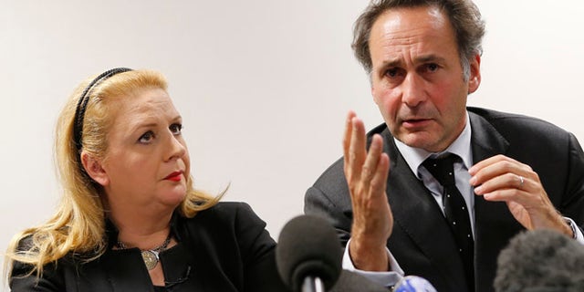 Dec. 3, 2013: Suha Arafat, left, flanked with her French Lawyer Pierre Olivier Sur, attend a press conference in Paris, France on Tuesday.