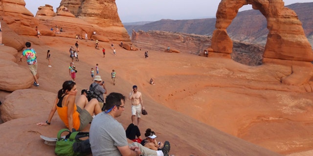 Tourists gather at the Arches National Park in Moab, Utah.