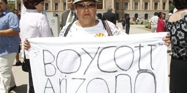 This April 29 file photo shows Josephine Nevarez, of Phoenix, holding a sign in protest of the Arizona immigration law at the Arizona Capitol in Phoenix. (AP Photo)