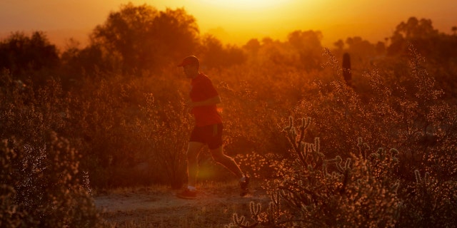 A man runs through the desert at sunrise, Friday, June 16, 2017, in Phoenix.