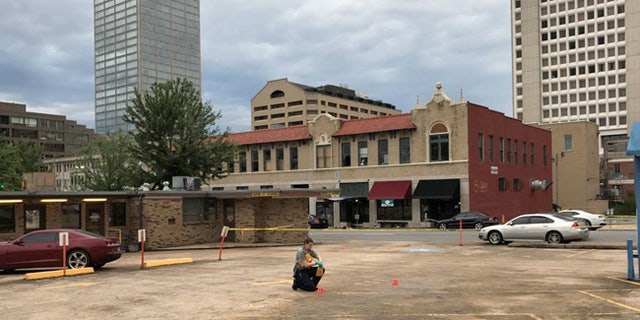 An investigator collects evidence near an Arkansas nightclub where police say multiple people were shot, Saturday, July 1, 2017, in Little Rock, Ark. (AP Photo/Andrew DeMillo)