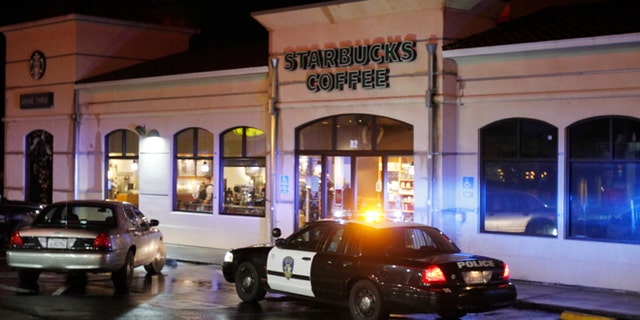 Vallejo Police officers work at the scene of a shooting in Vallejo, Calif., on Sunday, Oct. 16, 2016. Andrew Powell targeted two Northern California police officers who were taking a break at a coffee shop in an ambush that was foiled when his gun malfunctioned, a police chief said Monday.