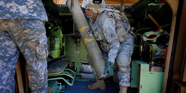 Feb. 25, 2014: U.S. Army Corp. Jacqueline Beachum lifts a 65-pound dummy T.O.W. missile into the launcher of a Bradley Fighting Vehicle during a physical demands study in Ft. Stewart, Ga. The Army is conducting a study that will determine how all soldiers, including women, for the first time, will be deemed fit to join its fighting units from infantry platoons to tank crews.