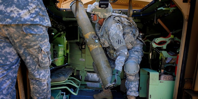 Feb. 25, 2014: U.S. Army Corp. Jacqueline Beachum lifts a 65-pound dummy T.O.W. missile into the launcher of a Bradley Fighting Vehicle during a physical demands study in Ft. Stewart, Ga. The Army is conducting a study that will determine how all soldiers, including women, for the first time, will be deemed fit to join its fighting units from infantry platoons to tank crews.