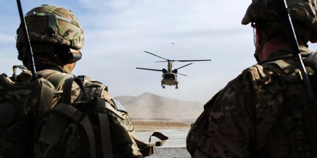 File photo - U.S. soldiers from the 3rd Cavalry Regiment watch as CH-47 Chinook helicopter from the 82nd Combat Aviation Brigade lands after an advising mission at the Afghan National Army headquarters for the 203rd Corps in the Paktia province of Afghanistan December 21, 2014.