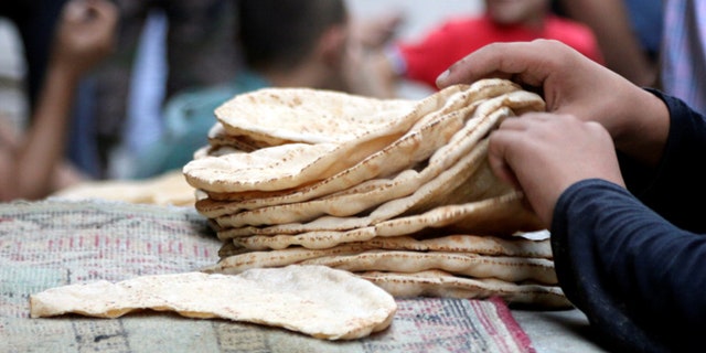A boy arranges bread in the rebel held al-Shaar neighbourhood of Aleppo