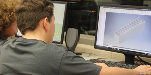 Students study a computer-generated image of the device (Screenshot from Samsung YouTube video)
