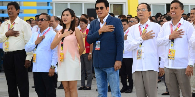 In this handout photo provided by the Tanuan City Information Office, Tanauan city Mayor Antonio Halili, third from right, attends a flag raising ceremony minutes before he was shot outside the municipal hall.