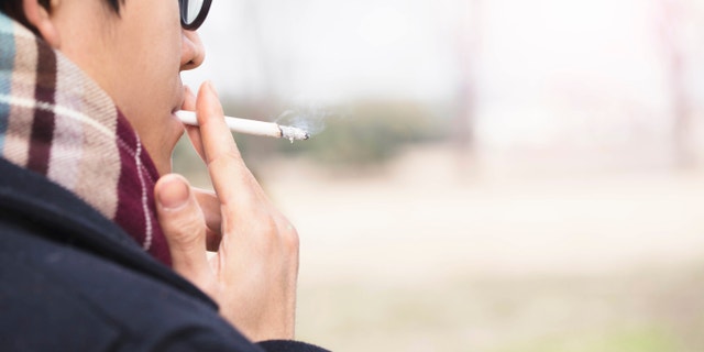 asian man smoking istock