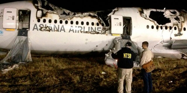 National Transportation Safety Board (NTSB) investigators conduct first site assessment of the wreckage of Asiana Airlines Flight 214, at San Francisco International Airport in San Francisco, California in this July 6, 2013 handout photo.