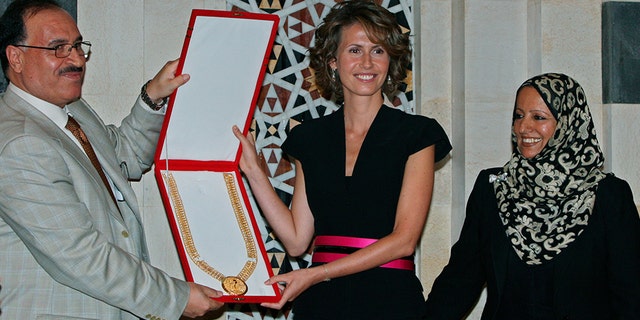 August 27, 2008: Karim Farman, Chairman of Paris-Based Arab Woman Studies Center, left, and member Shakour Al-Ghomari, right, give Syria's first lady Asma Assad the Center's prize of the Arab First Lady of 2008, in Damascus. The prize was awarded to Assad for her role in sponsoring National projects aimed at enhancing education and development in rural areas in Syria.