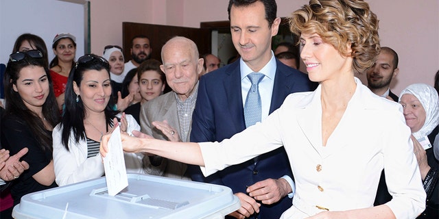 June 13, 2014: Syria's President Bashar Assad and his wife Asma cast their votes in the country's presidential elections at a polling station in Damascus.