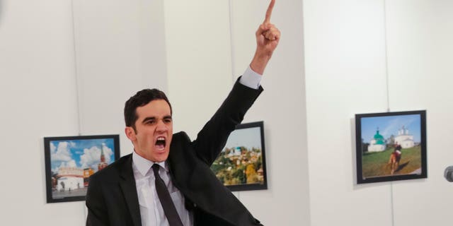 In this Monday, Dec. 19, 2016 file photo, Mevlut Mert Altintas shouts after shooting Andrei Karlov, right, the Russian ambassador to Turkey, at an art gallery in Ankara, Turkey.
