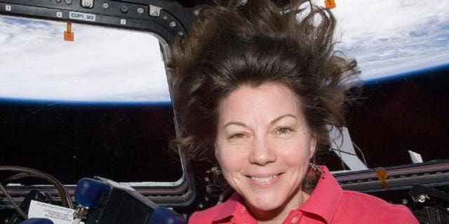 NASA astronaut Cady Coleman, Expedition 27 flight engineer, is pictured in the Cupola of the International Space Station. Earth’s horizon and the blackness of space are visible through the windows.