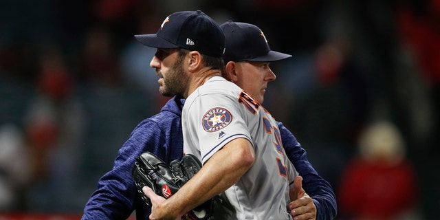 Houston Astros starting pitcher Justin Verlander gets a pack on the back from manager A.J. Hinch after the team's 2-0 win over the Los Angeles Angels in a baseball game Wednesday, May 16, 2018, in Anaheim, Calif.