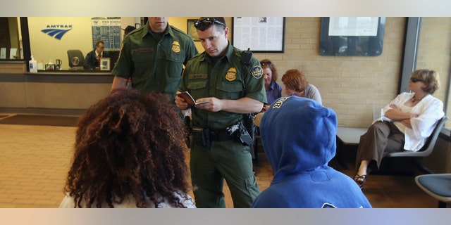 DEPEW, NY - JUNE 05: U.S. Border Patrol agents check passenger identifications at a train station on June 5, 2013 in Depew, New York. The agents set up a 24 hour check of transportation hubs in and around Buffalo. They said they received intelligence of undocumented immigrants passing through the area. The Border Patrol also monitors cross border traffic along the northern border between the United States and Canada. (Photo by John Moore/Getty Images)