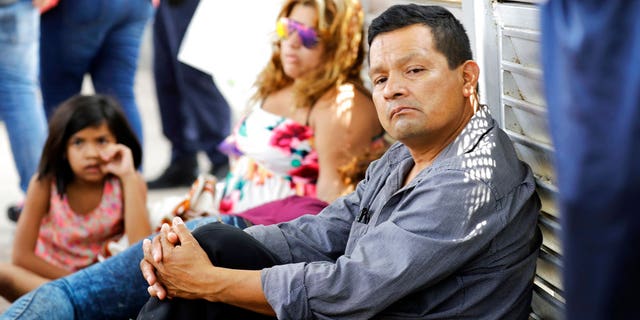Ruben Prado, right, an immigrant from Guatemala seeking asylum in the United States, waits on the Gateway International Bridge along with a family from Honduras, in Matamoros, Mexico on Sunday, June 24, 2018. Prado arrived at the bridge today after traveling for 20 days. (AP Photo/David J. Phillip)