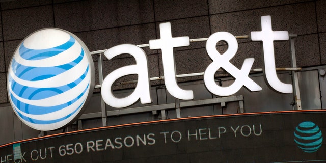 FILE - In this Oct. 24, 2016, file photo, the AT&amp;T logo is positioned above one of its retail stores in New York.