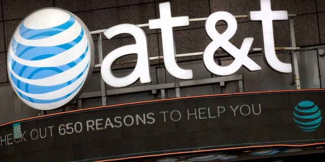 FILE - In this Oct. 24, 2016, file photo, the AT&amp;T logo is positioned above one of its retail stores in New York.