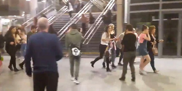 This image shows people running through Manchester Victoria station after an explosion at Manchester Arena on May 22, 2017.