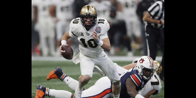 Central Florida quarterback McKenzie Milton (10) runs out of the pocket against Auburn during the first half of the Peach Bowl NCAA college football game Monday in Atlanta. (AP Photo/John Bazemore)