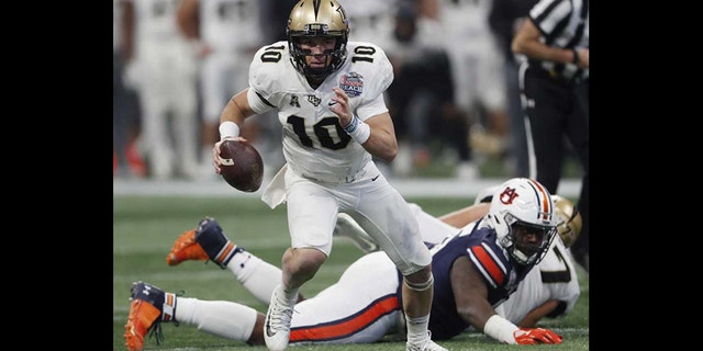 Central Florida quarterback McKenzie Milton (10) runs out of the pocket against Auburn during the first half of the Peach Bowl NCAA college football game Monday in Atlanta. (AP Photo/John Bazemore)