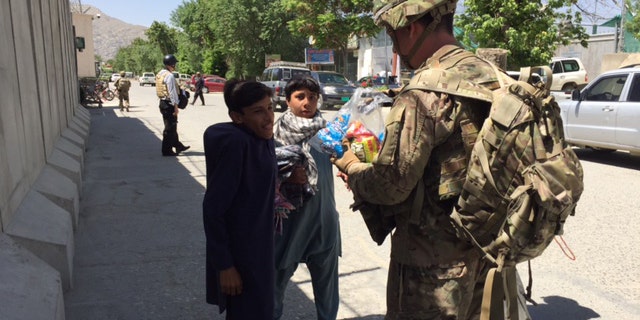 Major Jared Auchey with street children outside U.S. base in Kabul