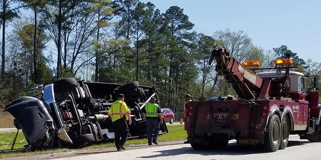 Police officers and emergency workers examine the scene of the accident scene Thursday morning, April 5, 2018.