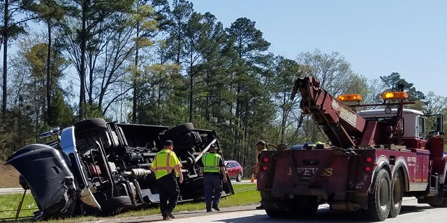 Police officers and emergency workers examine the scene of the accident scene Thursday morning, April 5, 2018.