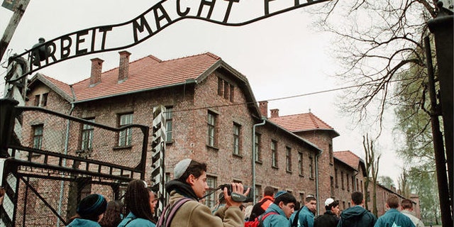 Young Israelis walk under the sign at Auschwitz concentration camp reading "Arbeit Macht Frei," (Work makes you Free).