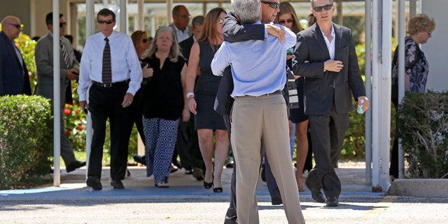 Mourners exit the Parker Playhouse following a memorial service for John Stevens and his wife Michelle Mishcon, Friday, Aug. 19, 2016, in Fort Lauderdale, Fla. A Florida sheriff's office said Friday, that Austin Harrouff, 19, will be charged with two counts of first-degree murder in the couples death, raising the possibility of the death penalty.