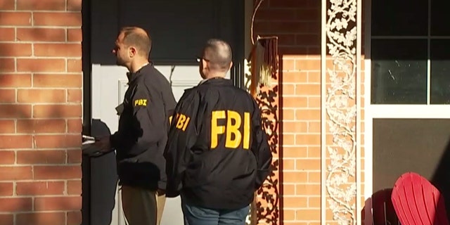 FBI agents can be seen in an Austin neighborhood after an explosion at a home left a teenager dead and a woman injured.