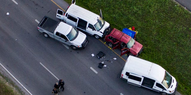 Officials investigate near a vehicle, center, where a suspect in the deadly bombings that terrorized Austin blew himself up as authorities closed in on him, in Round Rock, Texas, Wednesday, March 21, 2018.