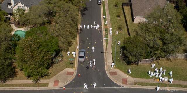 Investigators on Monday March 19, 2018, work at the scene of a bomb explosion on Dawn Song Drive in Austin, Texas, that seriously injured two men Sunday.